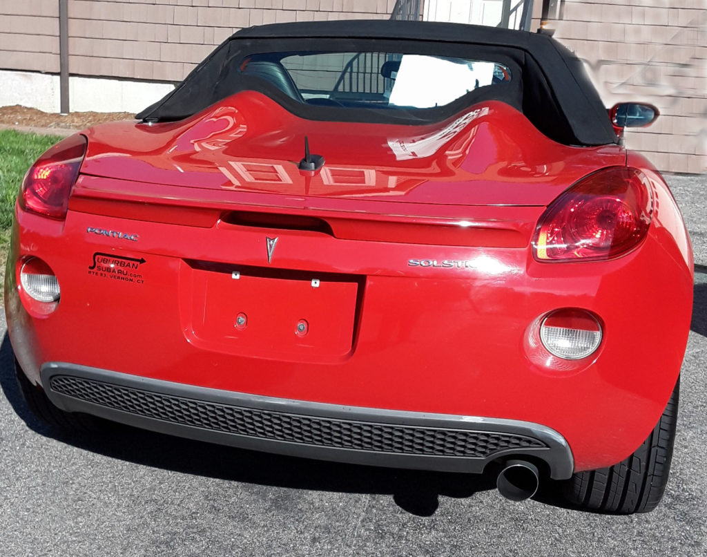 Back view of red and black 2008 Pontiac Solstice with top up.