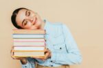 Smiling woman holding a stack of books